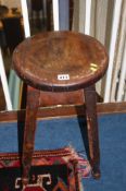 A wooden circular topped stool