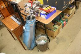 An assortment of golf clubs, metal coal bin etc.