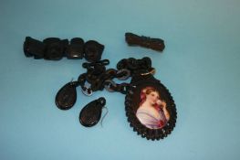 A Victorian oval jet pendant, inset with a porcelain plaque, a jet bracelet, pair of earrings and