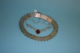 A decorative necklace and a silver coloured collarette