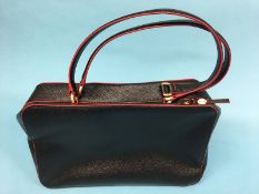 Black leather handbag with red trim, black and white stripe lining