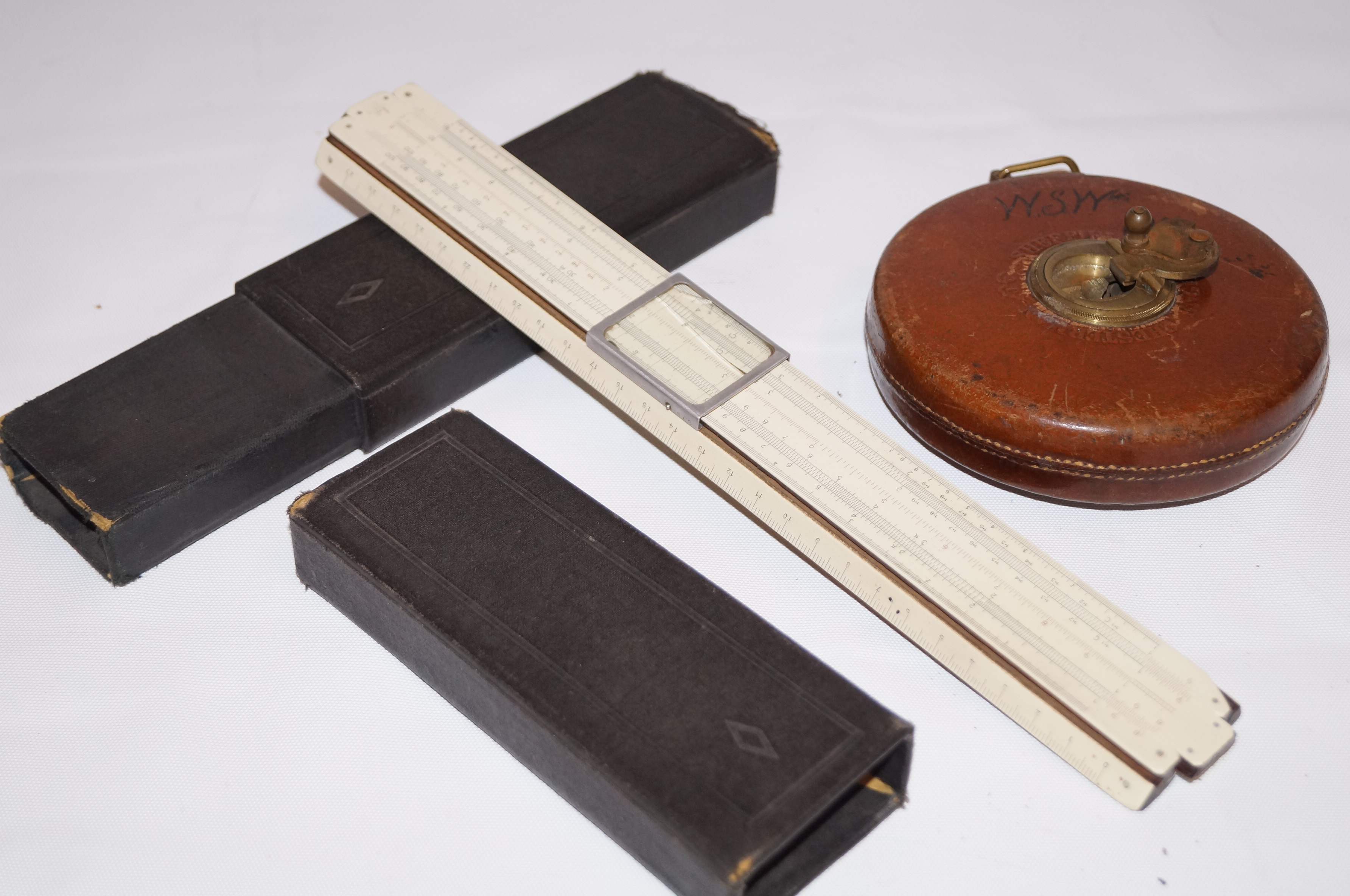 Leather bound tape measure together with slide rul