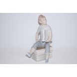 Nao figure of a boy holding newspaper Height 24 cm