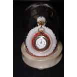 Gold plated fob watch set on a onyx stand covered