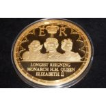 Large commemorative gold plated coin longest reign