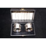 Cased pair of silver napkin rings with personal de