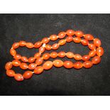 A string of 47 amber beads each bead with many inc