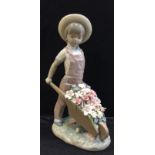 A Lladro girl with wheelbarrow and flowers