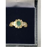 A diamond and emerald dress ring