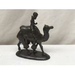 A bronze statue of a man riding a camel