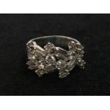 An unhallmarked diamond abstract ring set with baguette and brilliant cut stones
