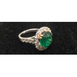 An 18ct large 6ct Zambian emerald ring and diamond set shoulders