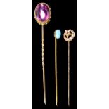 Three Gold Stick Pins: To include cabochon amethyst with white enamelling,