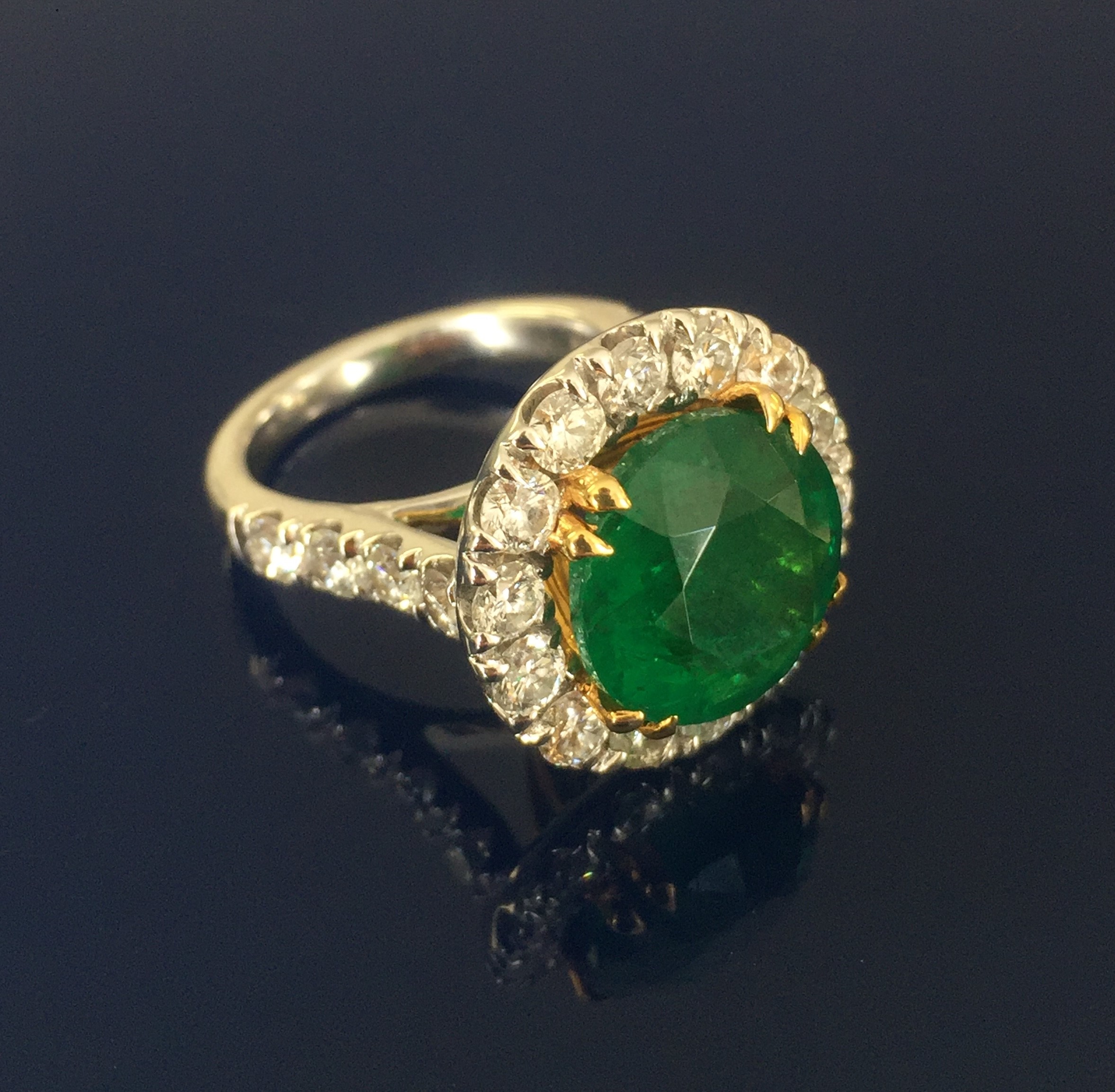 An 18ct large 6ct Zambian emerald ring with diamond set shoulders