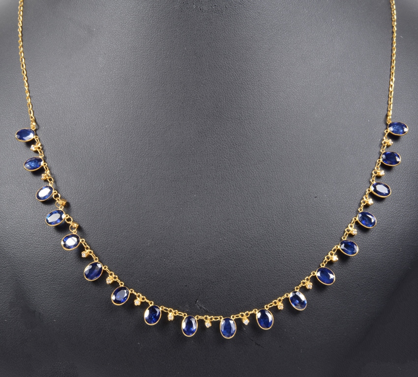 An 18ct Sapphire and Diamond Necklace: 18 oval cut sapphires interspersed with diamonds between