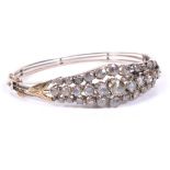 An Antique Rose Cut Diamond Bangle: The unhallmarked gold hinged bangle comprising three layered