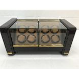 A Time Mover 8 watch watch winder enclosed in a glass display case with pull out drawers for