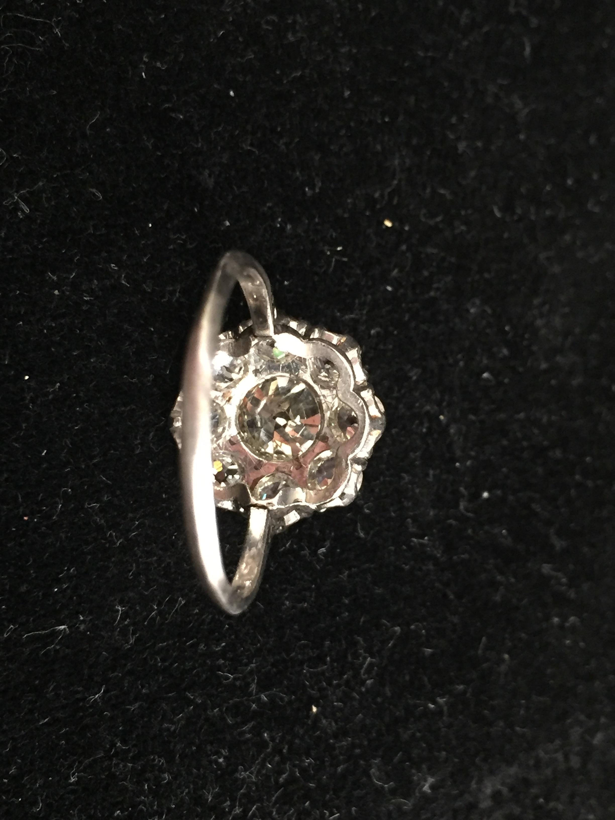 A platinum diamond daisy ring, central old brilliant cut stone: spreads 1.5ct; Moes measure 1. - Image 3 of 4