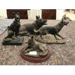 A bronze figure of a german shepherd together with 3 other german shepherd figures