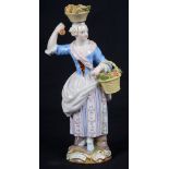 A 19th Century Meissen Figure of a Lady Fruit Seller: With a basket of fruit on her head and one