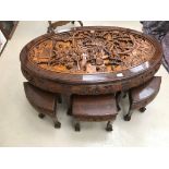 An Oriental carved hardwood table and stools