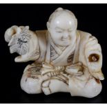 A Japanese ivory okimono Meiji period Carved as a sitting man holding a leaf with the character for