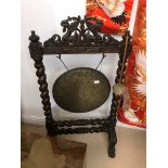 An oak framed gong with carved dragons to the top