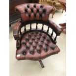 A leather buttonback swivel captain's chair