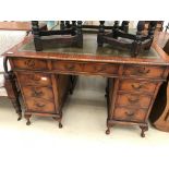 A mahogany twin pedastal leather-topped desk