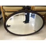 A mahogany oval mirror in the Adams style