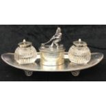 A Victorian HM silver boat-shaped desk inkwell set with a 19th century sailor pulling a rope around