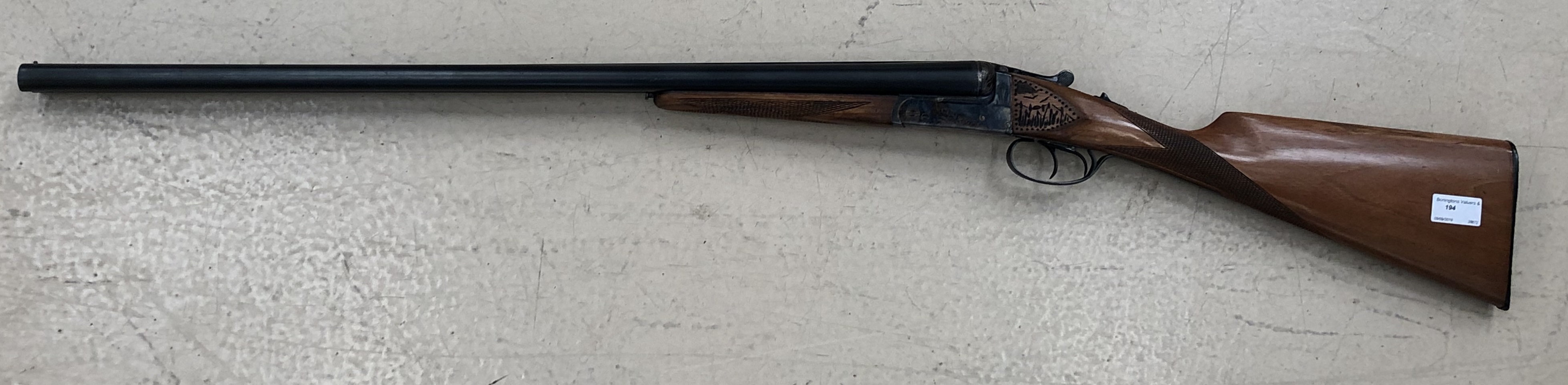 An Essex Arms 12 bore double barrel shotgun with gold inlay to the lever and engraved dog