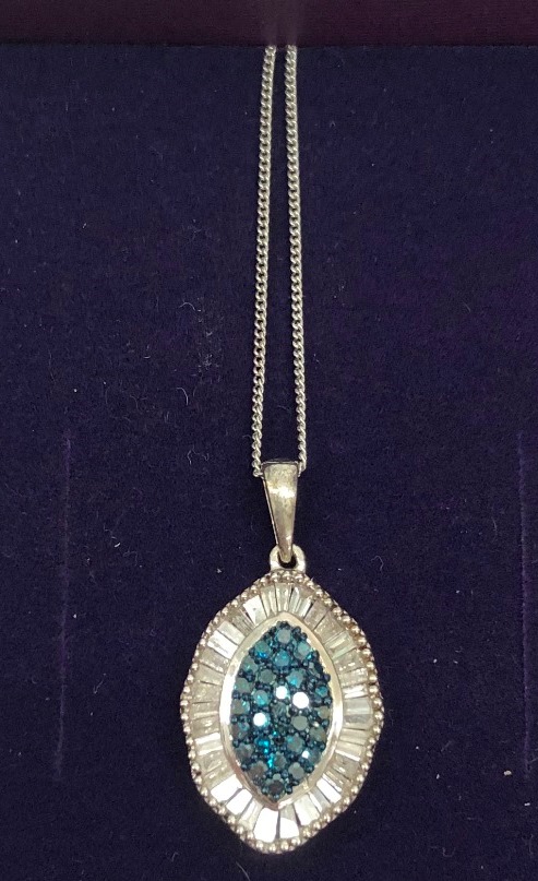 A silver diamond and blue diamond pendant