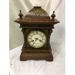 An ornate mantel clock in an oak case