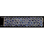 A Silver Sapphire Set Bracelet: Comprising 53 pear-shape and oval cut sapphires with harlequin