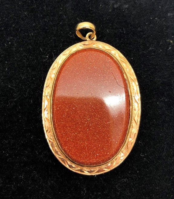 An unmarked gold and semi-precious stone brooch