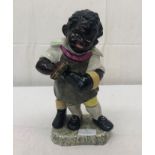 A ceramic figure of a boot polisher