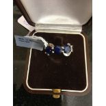 A silver and large sapphire set trilogy ring