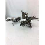 Two metal figures of a dragon and a rhino