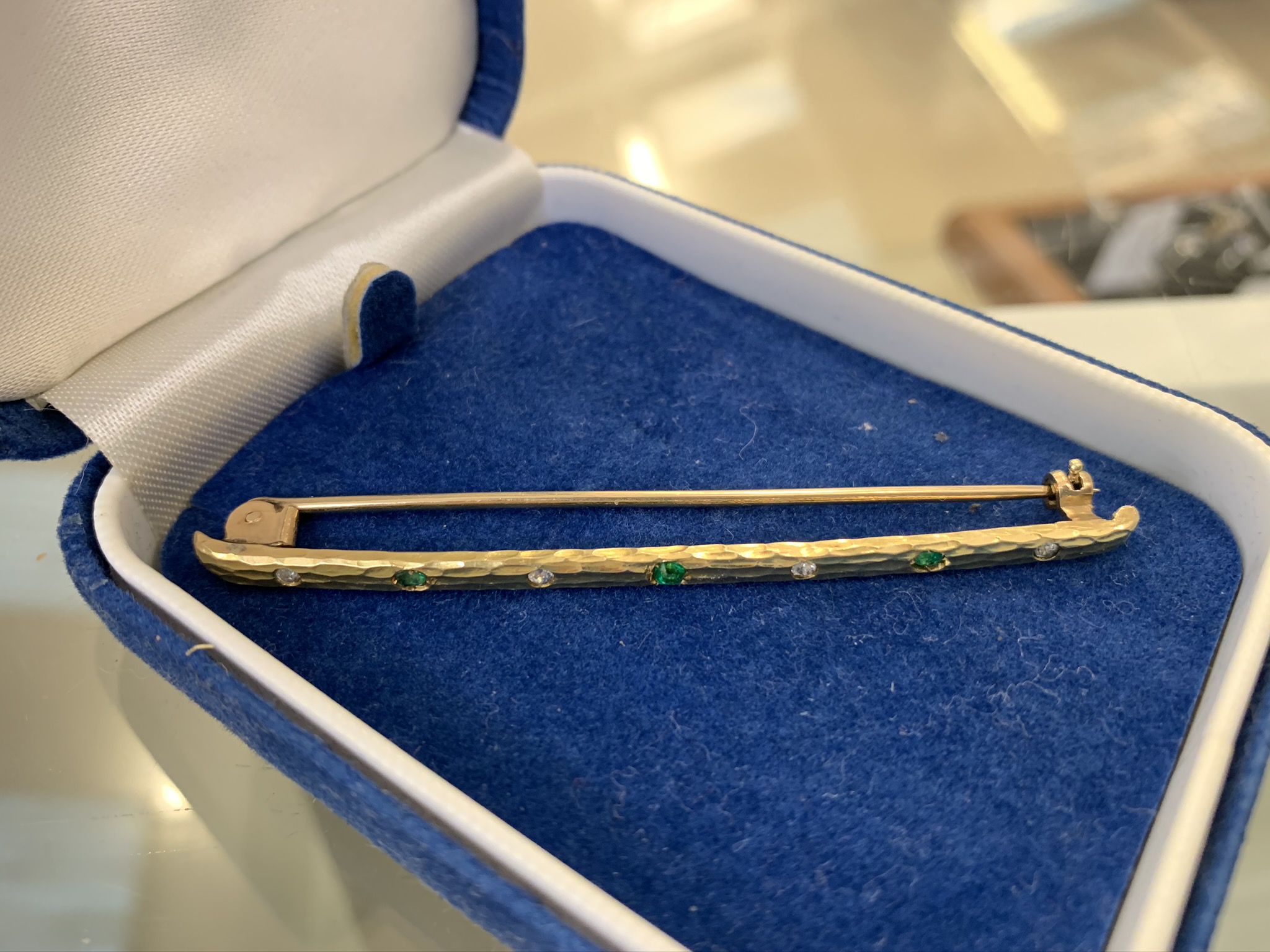 A diamond and emerald bar brooch