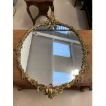 A gilt framed mirror with elaborate floral,