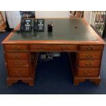 A mahogany twin pedestal partner's desk with drawers either side and a green leather top