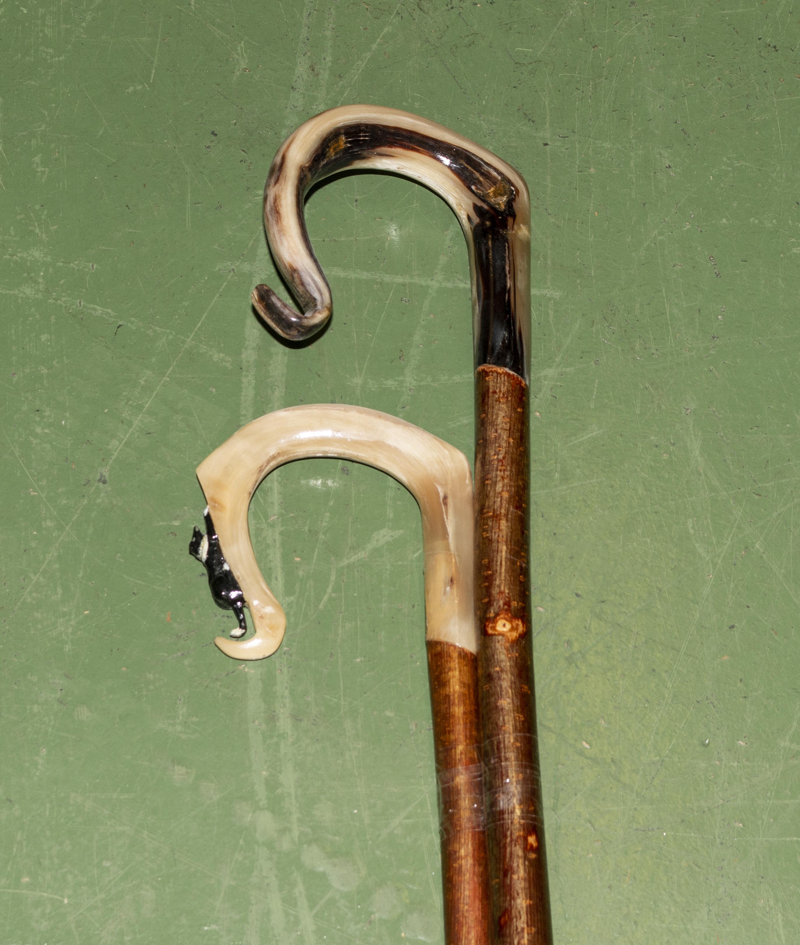 Two horn crooks one with cat handle