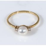 An 18ct gold ring set with a pearl and diamonds, size O