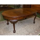 A mahogany ball and claw wind out dining table with centre leaf