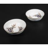 A pair of Japanese Arita Fukagawa porcelain bowls painted with floral scenes, underglaze blue orchid