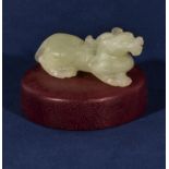 A jade mythical beast on a purlpeheart wooden stand