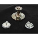 A small silver candlestick, a stop watch and one other