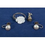 A pair of silver and pearl earrings, a silver flower ring and a charm