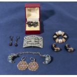 A collection of vintage costume jewellery including a belt buckle, three pairs of earrings, matching